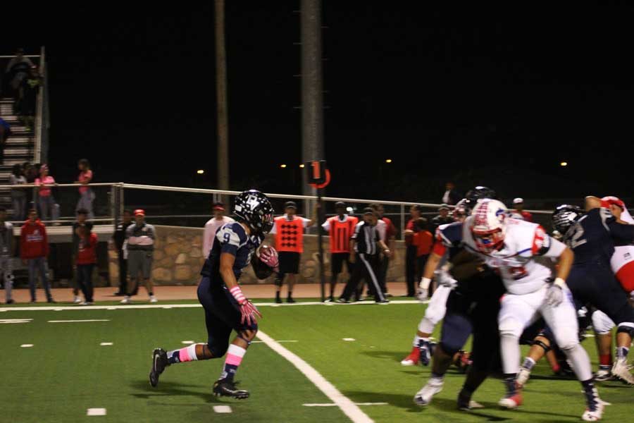 Running back Adrian, #9, finds a hole to attack and gain yards.