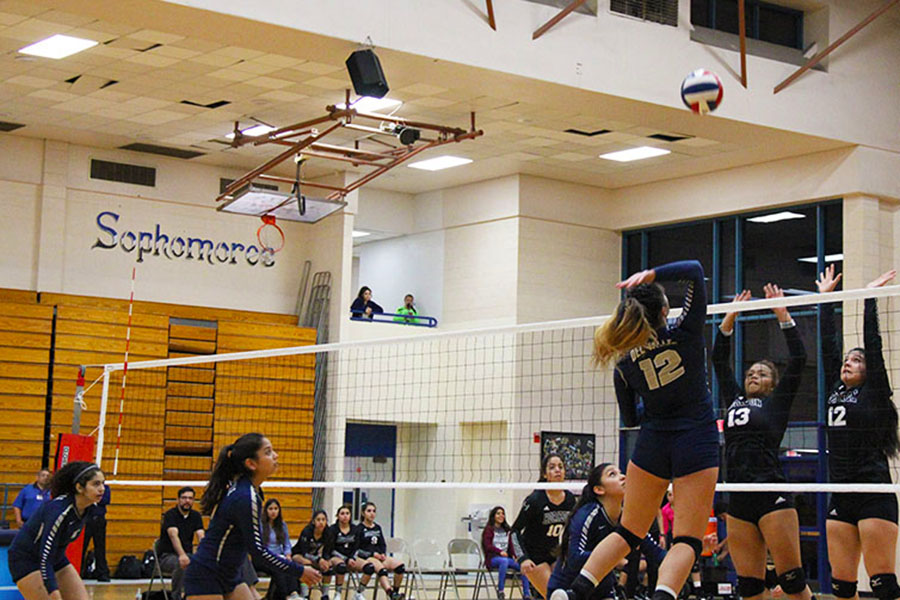 Varsity middle blocker Madison spikes the ball over two Horizon players, as Natalia, Bernadette, and Maya watch the play develop.  The team played three sets against the Scorpions, 0-3, Sept. 26.