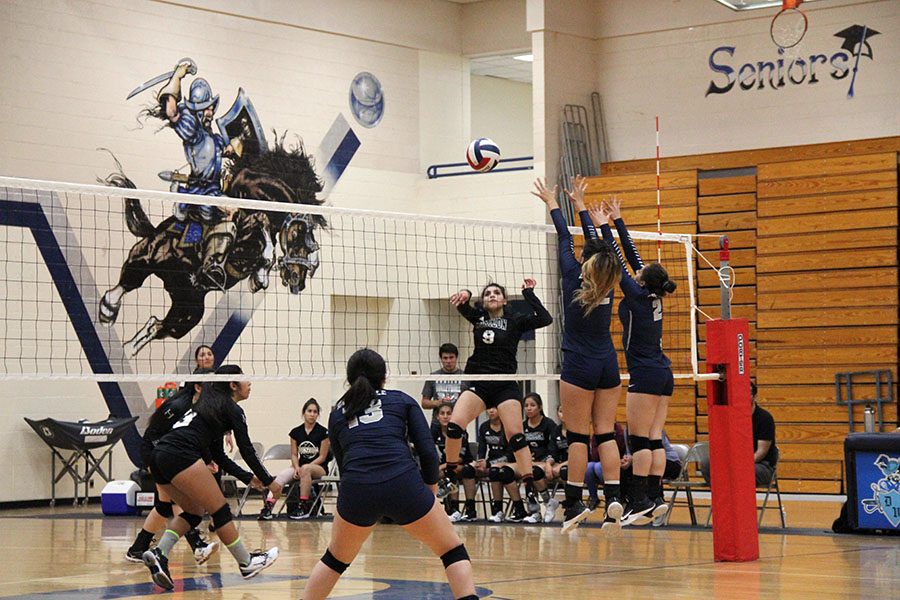 Madison, and Paola block an incoming spike from a Horizon player