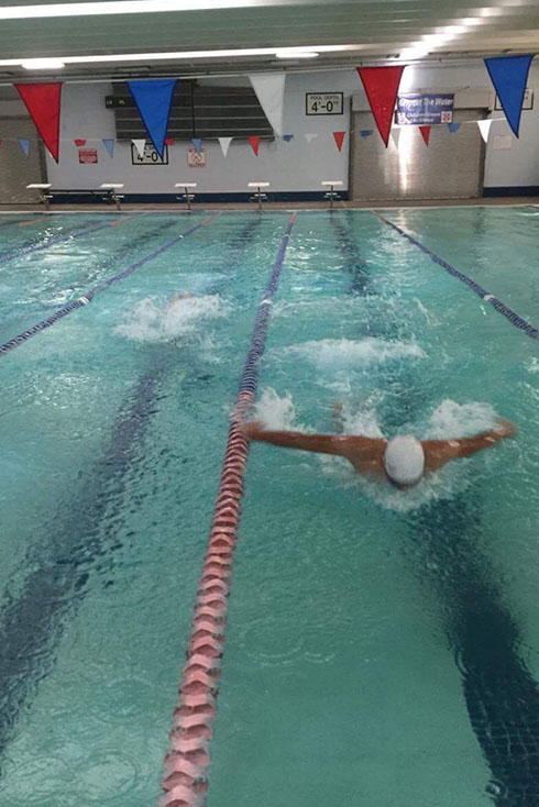 Swim team member Euardo practices the butterfly stroke.
