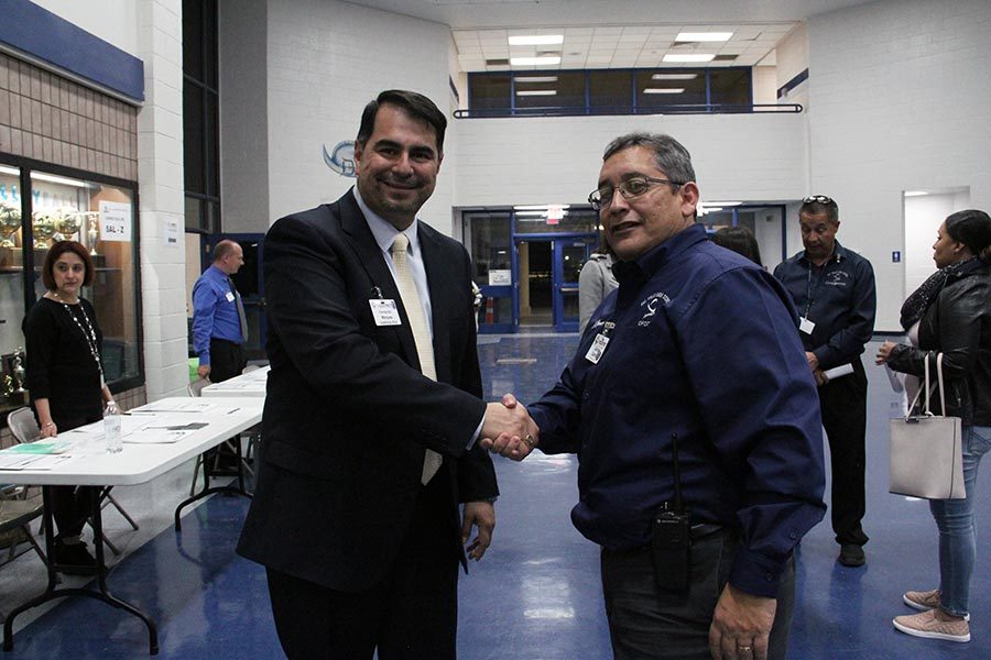 Assistant principal Gerald Gamez shakes hands with Career and Technology director Fernando Marquez.