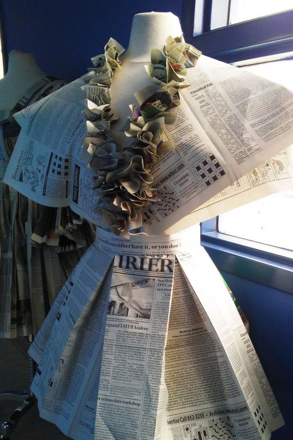 Fashion class students work on a project that requires a dress made out of newspaper. 