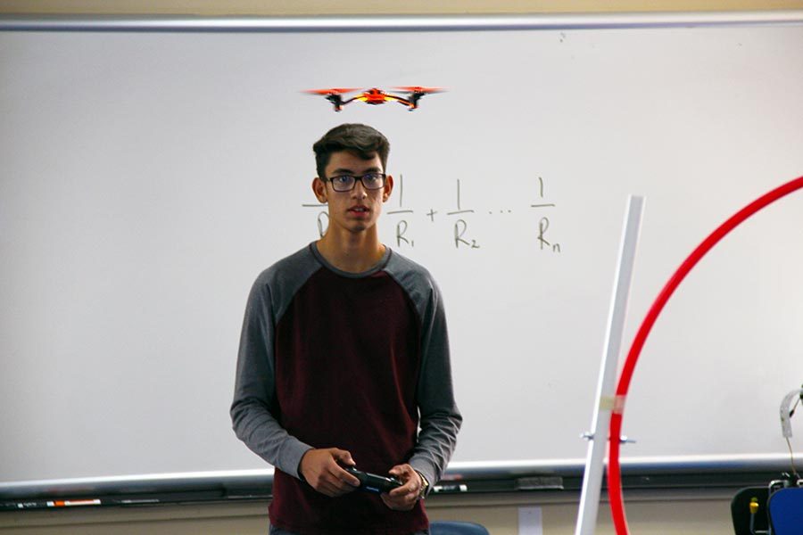 Sophomore David practices flying a drone through  a student-built obstacle course in A208.