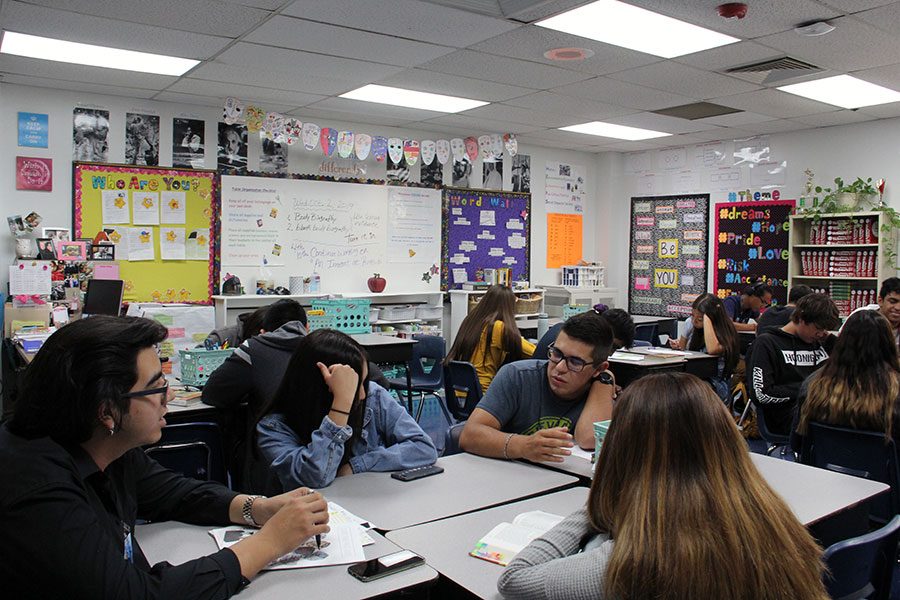 Juniors Danielle Garcia, Nicole Gongora, Ramon Urueta and Christian Valencia discuss the  class reading assignment in AP teacher Andrea Morses English III, Oct. 2.