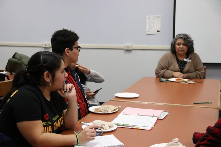 Librarian Elena Ortega, book club members Adan Aranda and Lilia  Castruita discuss meeting time changes. 