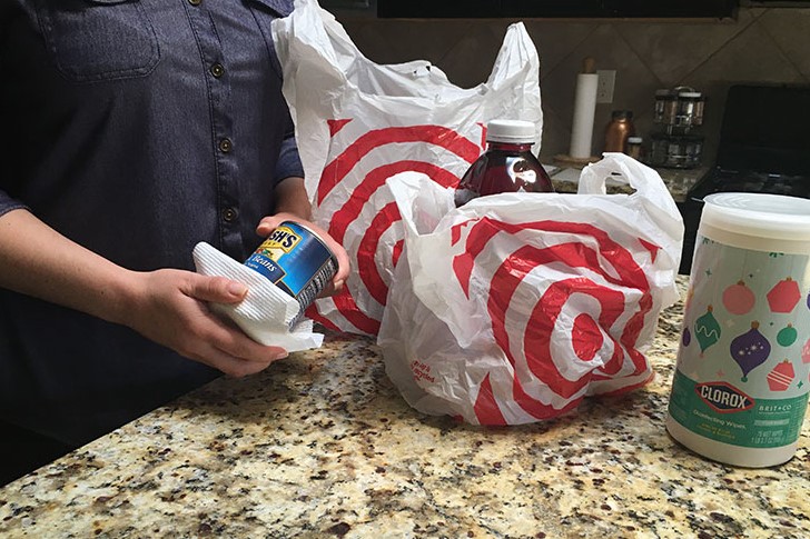 A customer from Target disinfects her groceries after leaving the store.