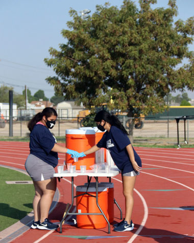 Athletes hydrate while following safety guidelines.