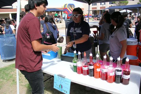 Student buys a raspa from Allison Davila and Adamarys Rivera at the Plaza Palooza to raise money for the student trainers. 